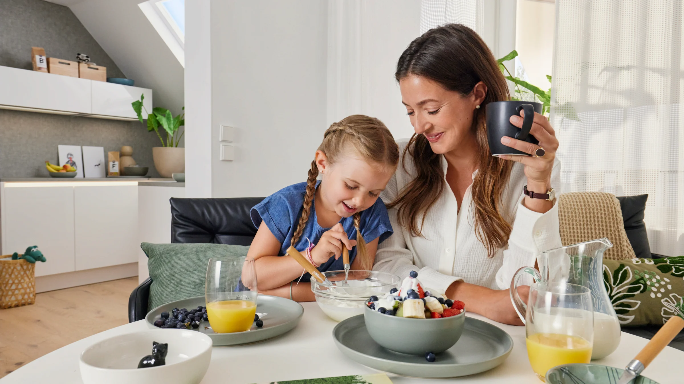 Madre e figlia fanno colazione insieme in una cucina moderna di Nolte Kitchen.
