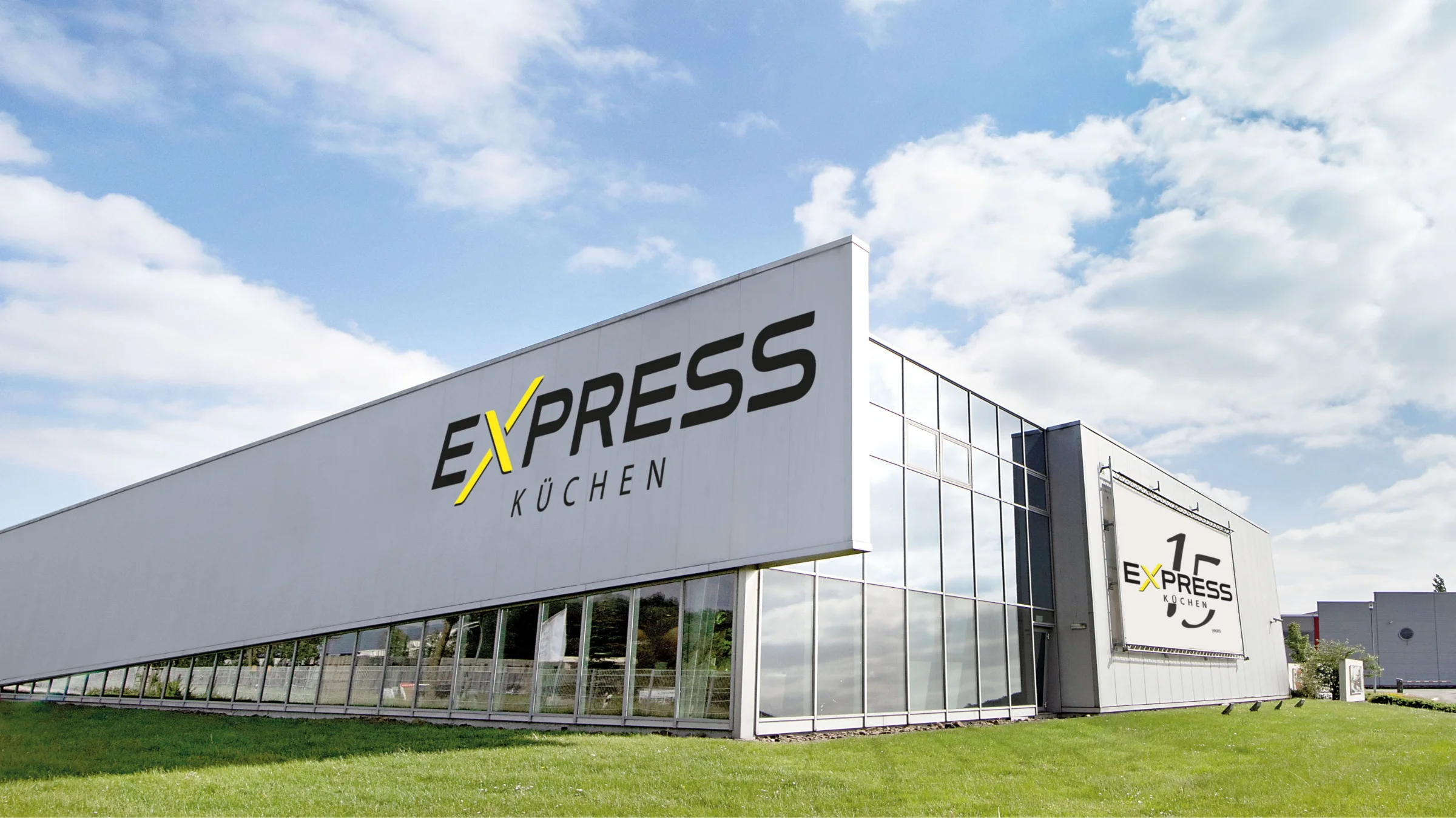 Un bâtiment moderne avec l'inscription "Express Küchen" sous un ciel bleu.