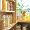 Scaffali da cucina con cibo alla luce del sole, piante e utensili sullo sfondo. Nolte Kitchen.