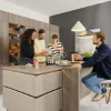 Una cucina moderna con quattro persone che cucinano insieme. Nolte Kitchen.