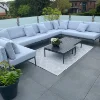 Terrazza moderna con divano lounge grigio e tavolo, circondata da piante.