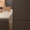 Cucina moderna con armadi scuri e piano di lavoro chiaro, Nolte Kitchen.