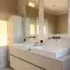 Bagno moderno con due lavabi e grande specchio, parte del Nolte SPA.
