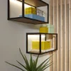 Mensole illuminate con oggetti decorativi, incluso un cactus su una credenza. Nolte Living.