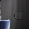 Elegante zona giorno con armadi neri e accenti blu, parte di Nolte Living.