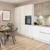 Cucina moderna con tavolo da pranzo e armadi bianchi, in stile Nolte Kitchen.