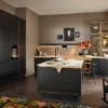 Cucina moderna con armadi scuri e isola; scaffali decorativi sullo sfondo. Nolte Kitchen.