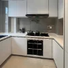 Cucina moderna bianca con lavello angolare e piano cottura di Nolte Kitchen.