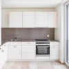 Modern kitchen with white cabinets and built-in appliances, designed by Nolte Kitchen.
