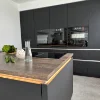 Cucina moderna con armadi scuri e isola, elegantemente progettata da Nolte Kitchen.