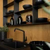Cucina moderna con piano nero e scaffali in legno, design Nolte Kitchen.
