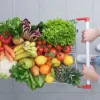 Una persona spinge un carrello della spesa pieno di frutta e verdura fresca su un pavimento di piastrelle grigie.