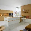 Cucina moderna con elementi bianchi e dorati, arredata da Nolte Kitchen.