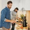 Una coppia prepara cibo in una cucina moderna, stile Nolte Kitchen.