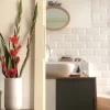 Un moderno bagno con piastrelle bianche ed elementi decorativi. Nolte Kitchen.