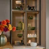 Elegante libreria da soggiorno con vasi di vetro e stoviglie, in stile Nolte Living.