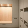 Elegante lavanderia con armadi moderni e illuminazione di Nolte Utility Rooms.