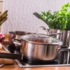 Ingredienti freschi e pentole su un piano cottura in una cucina moderna di Nolte Kitchen.