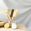 Spazzole naturali, mezzo limone e sale su un tavolo.