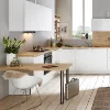 Cucina luminosa con armadi bianchi e dettagli in legno, tavolo e sedia a sinistra, finestra sullo sfondo. Nolte Kitchen.