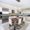 Cucina moderna con tavolo da pranzo, sedie ed elettrodomestici integrati. Nolte Kitchen.
