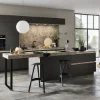 Cucina moderna con isola e armadi scuri, grandi finestre sullo sfondo. Nolte Kitchen.