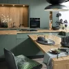 Cucina moderna in verde con accenti in legno e decorazioni eleganti di Nolte Kitchen.