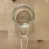 A glass tied with a rope to a hanging container.
