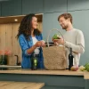 Una coppia disfa le verdure in una cucina moderna Nolte.