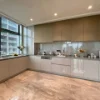 Cucina moderna con armadi grigi e piastrelle in marmo, arredata da Nolte Kitchen.