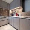 Cucina moderna con armadi grigi e parete in marmo, dotata di cucine Nolte.