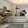 Cucina moderna con isola e sgabelli, decorata con piante e opere d'arte. Nolte Kitchen.