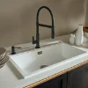 Cucina moderna con lavello bianco e rubinetto nero di Nolte Kitchen.