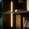 Une étagère élégante avec éclairage et boîtes décoratives.