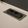 Una presa nera integrata in un piano di lavoro chiaro. Cucine Nolte.