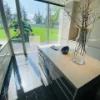 Una cucina moderna con grandi finestre e un'isola centrale, progettata da Nolte Kitchen.