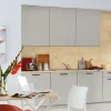 Cucina moderna con armadi grigi e dettagli in legno, tavolo con fiori. Nolte Kitchen.