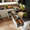 Cucina moderna con cassetti aperti e erbe fresche sul piano di lavoro. Nolte Kitchen.