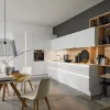 Cucina moderna con armadi bianchi e dettagli in legno, progettata da Nolte Kitchen.