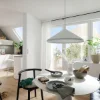 Un luminoso soggiorno con tavolo da pranzo e angolo cottura, circondato da piante, presenta Nolte Living.