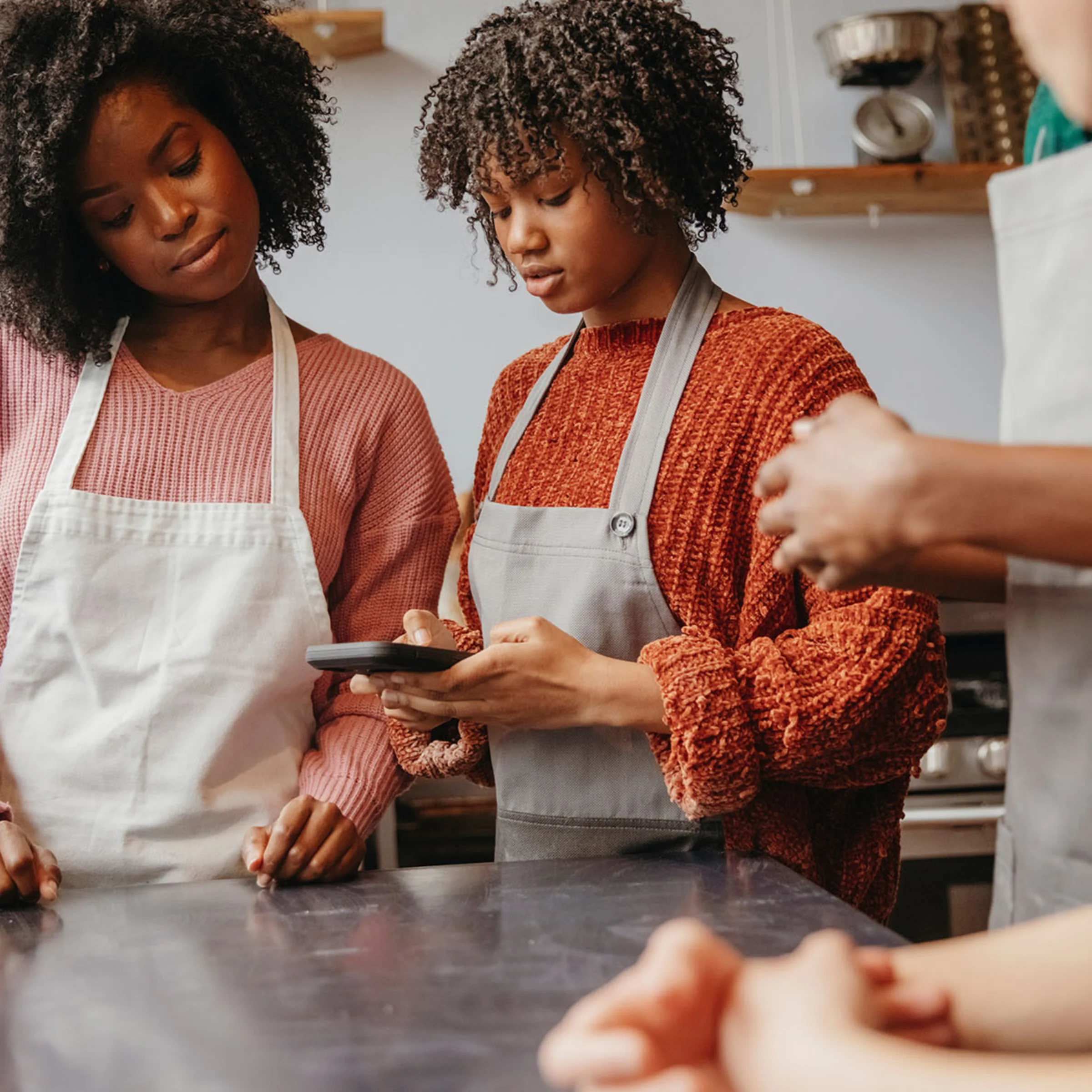 Due persone con grembiuli usano un tablet in una cucina moderna, Nolte Kitchen.