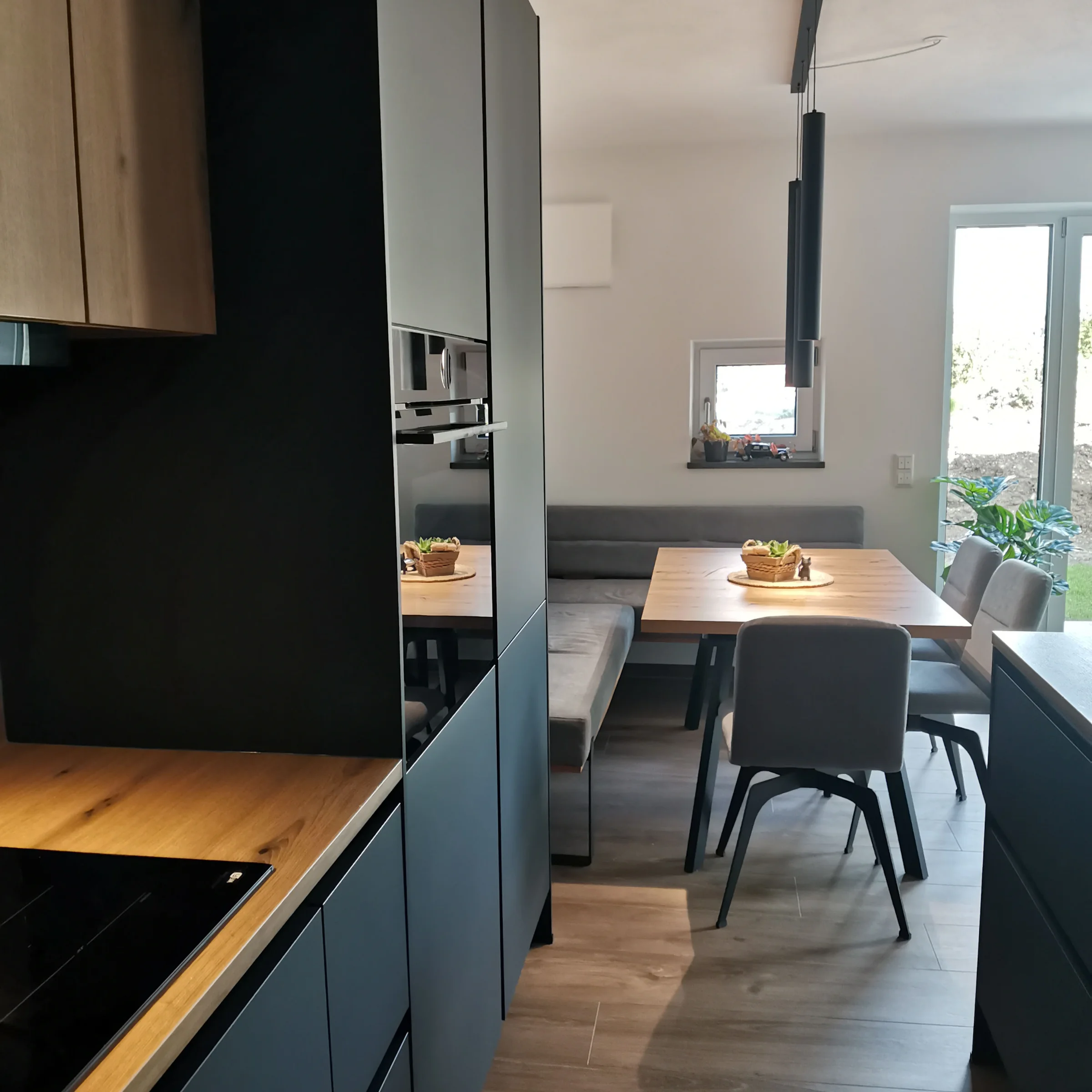 Cucina moderna con tavolo da pranzo e sedie, progettata da Nolte Kitchen.