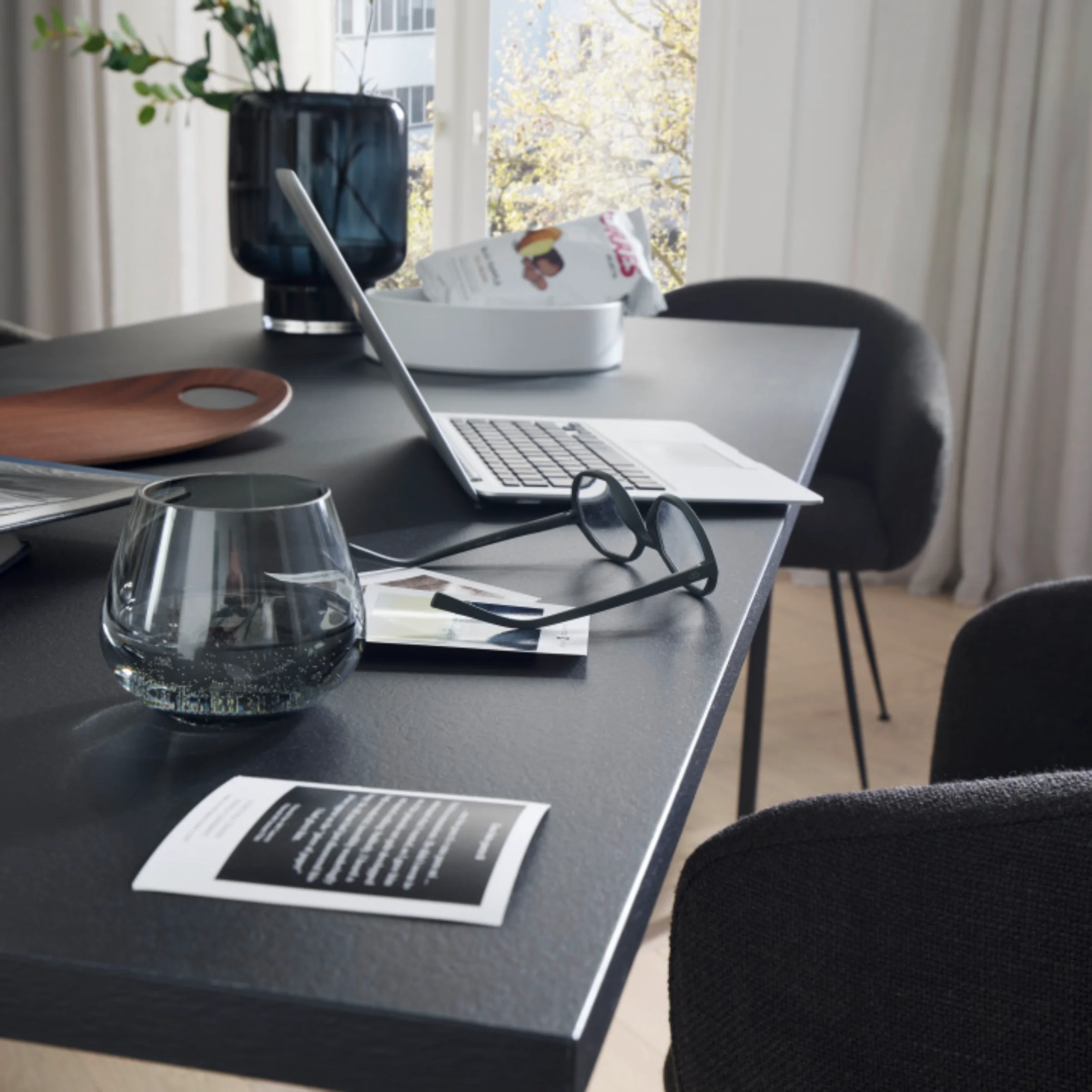 Soggiorno moderno con tavolo, laptop e decorazioni, in stile Nolte Living.