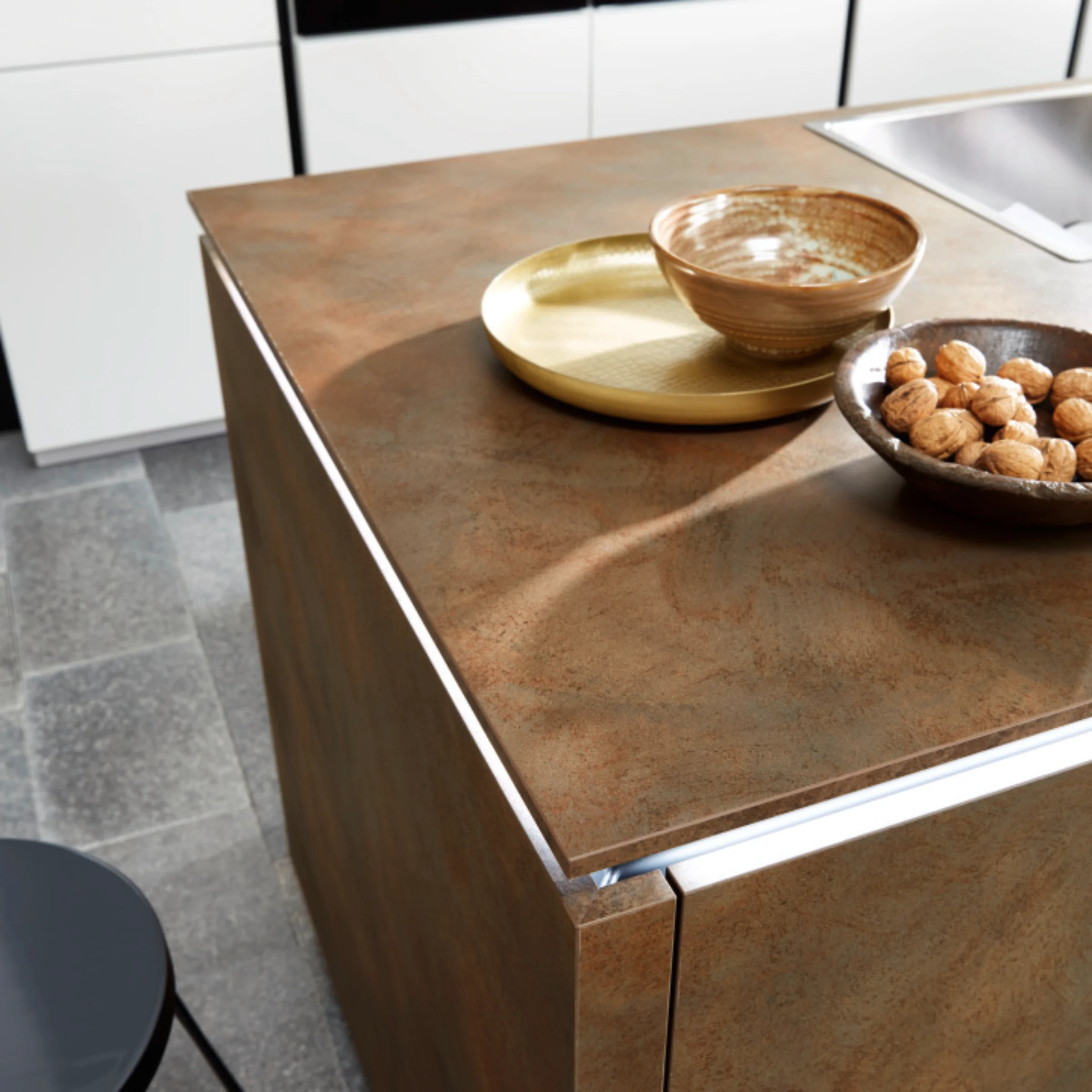 Cucina moderna con isola in effetto legno e lavello integrato di Nolte Kitchen.