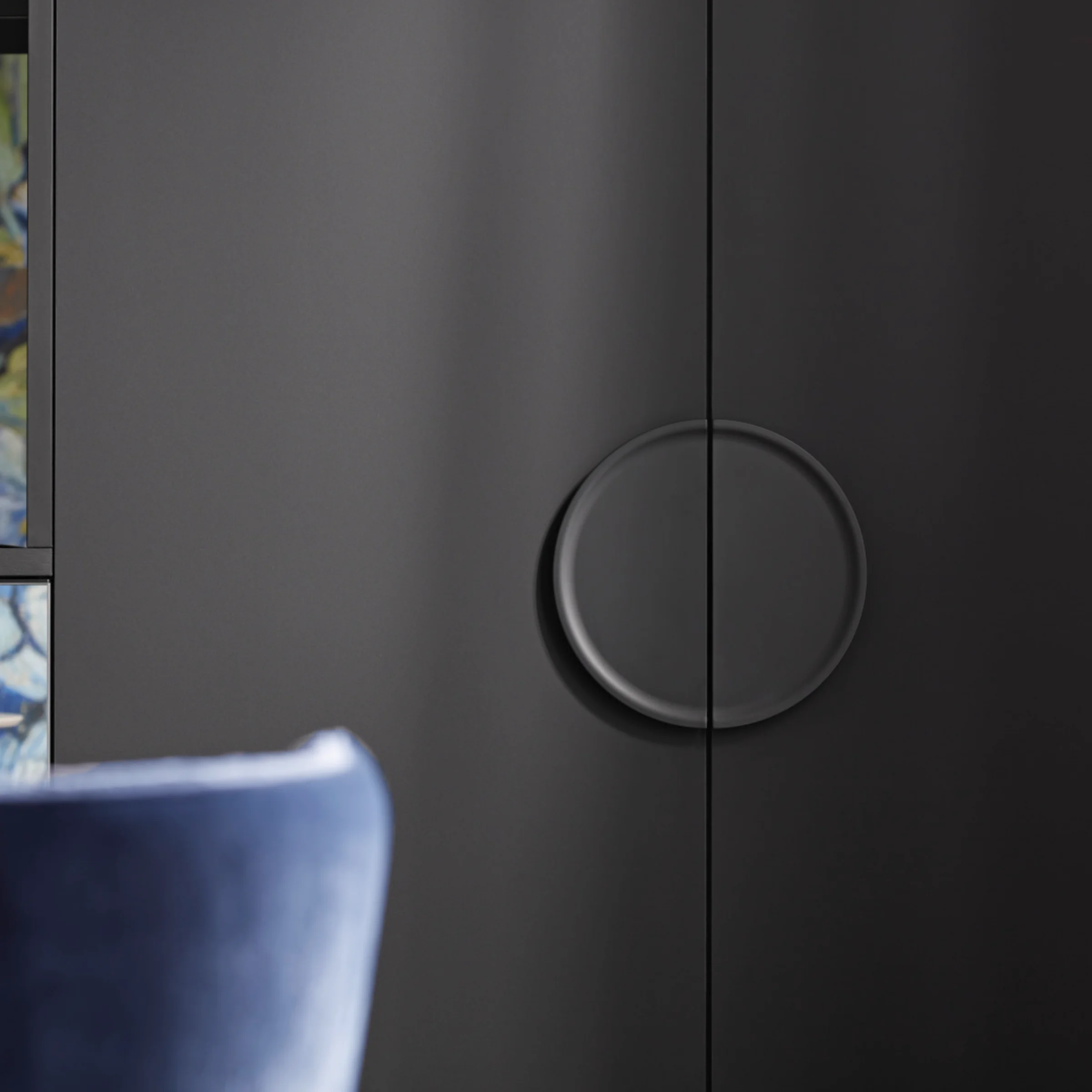 Elegante zona giorno con armadi neri e accenti blu, parte di Nolte Living.