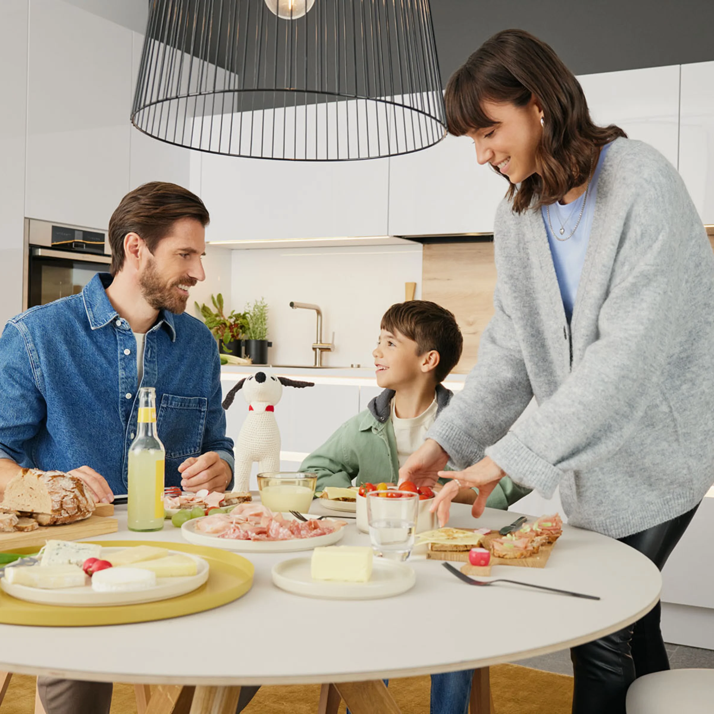 Una famiglia prepara la colazione insieme in una moderna cucina Nolte.
