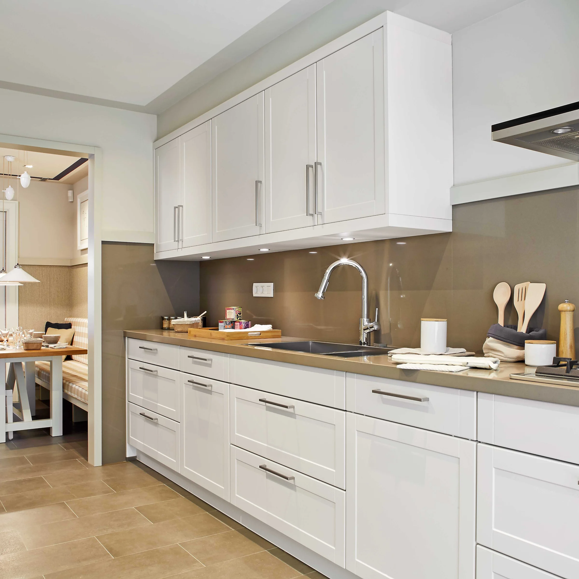 A modern kitchen with white cabinets and appliances, designed by Nolte Kitchen.