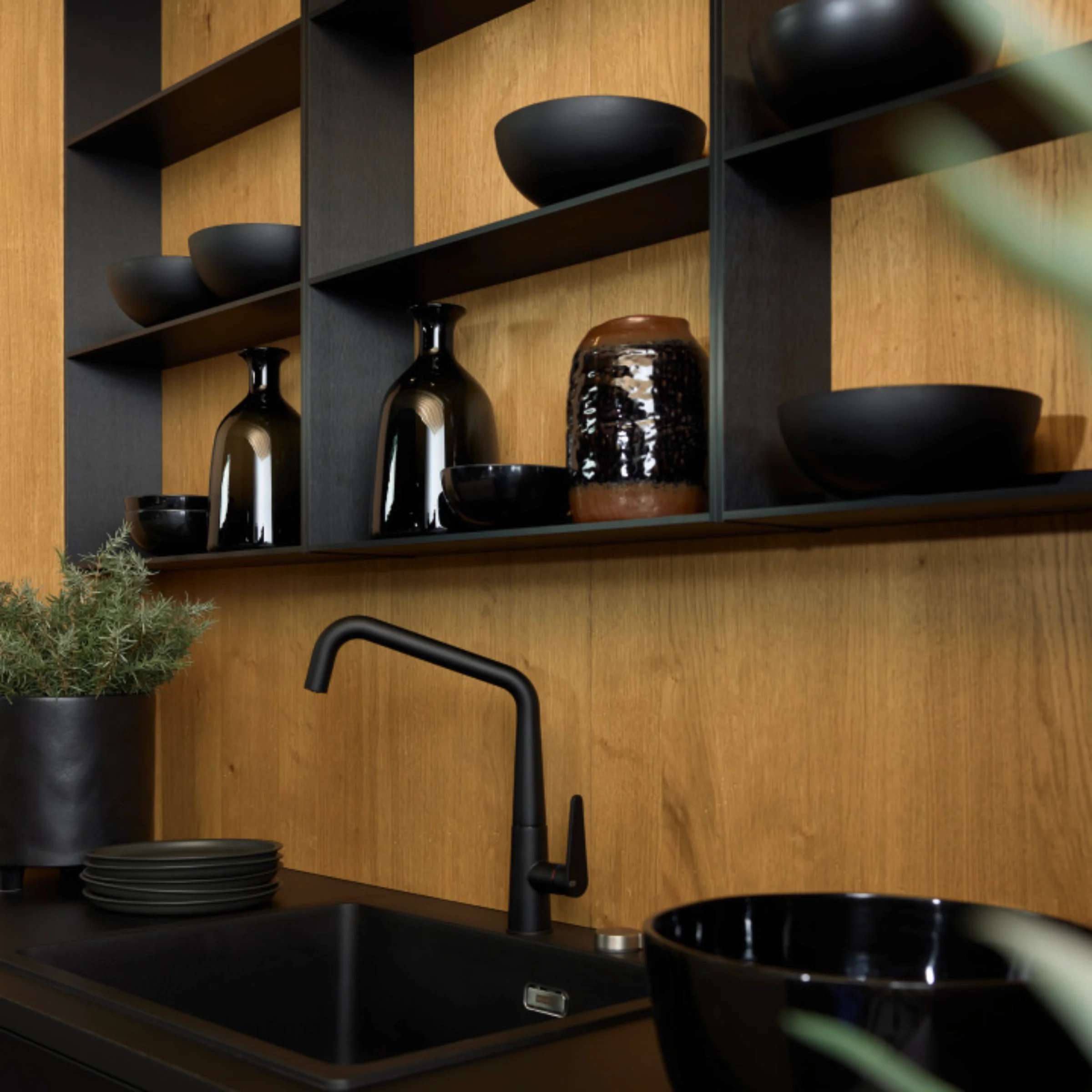 Cucina moderna con piano nero e scaffali in legno, design Nolte Kitchen.