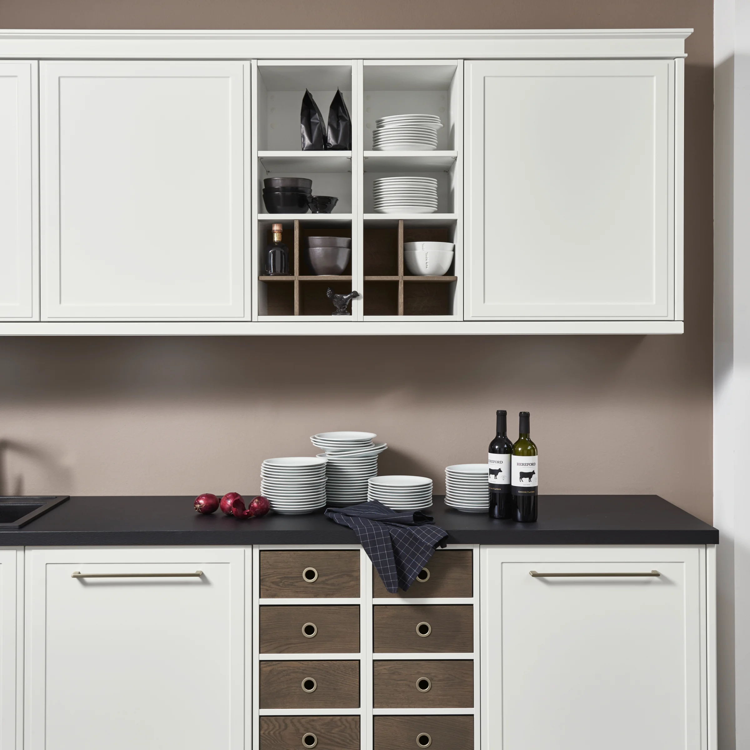 Cucina moderna con armadi bianchi e piano di lavoro scuro, presentata da Nolte Kitchen.
