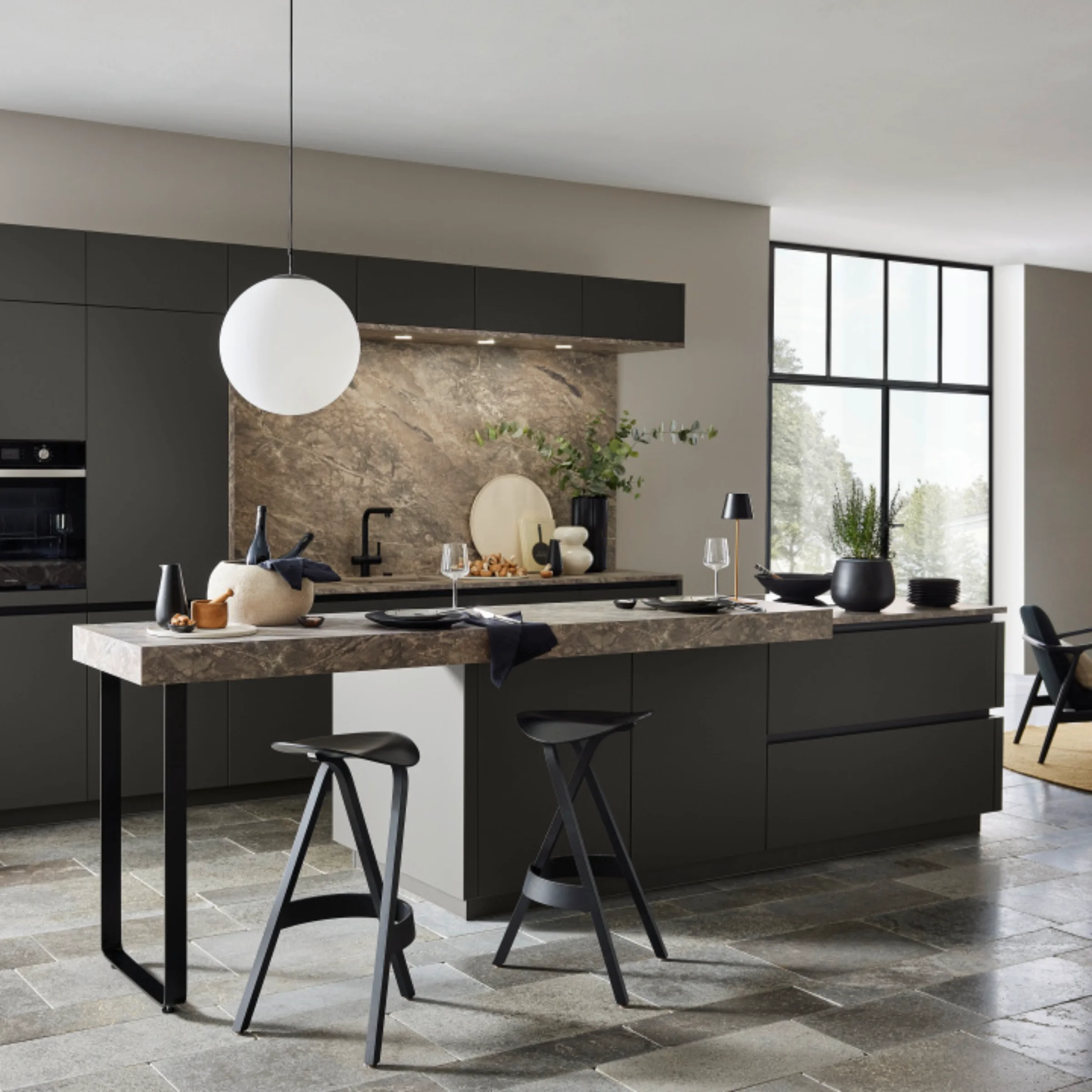 Cucina moderna con isola, sgabelli e piastrelle in pietra; design Nolte Kitchen.